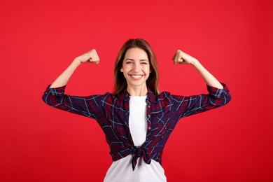 Strong woman as symbol of girl power on red background. 8 March concept