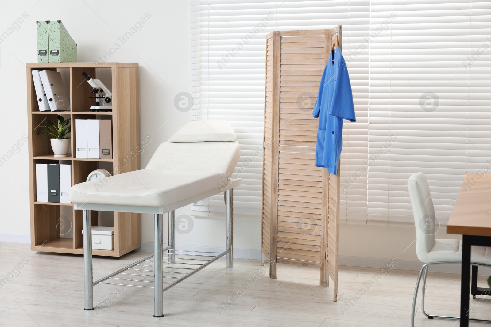 Photo of Modern medical office with doctor's workplace and examination table in clinic