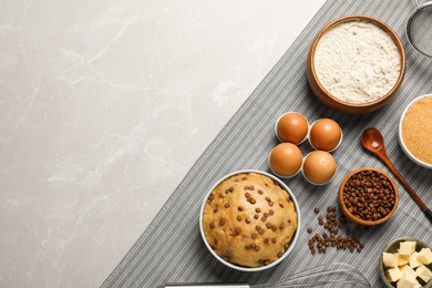 Dough and ingredients for cooking chocolate chip cookies on light grey table, flat lay. Space for text