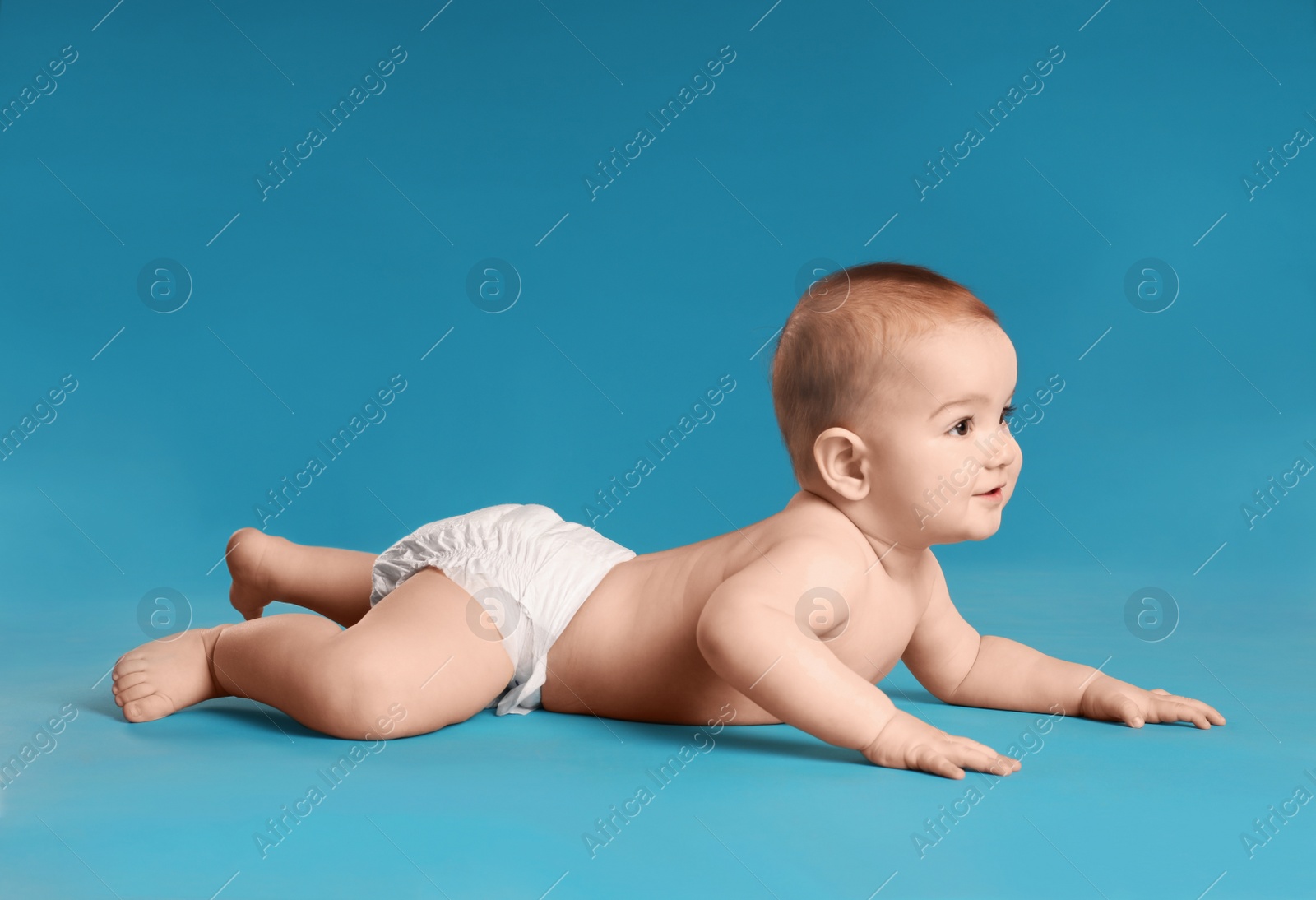 Photo of Cute little baby in diaper on light blue background