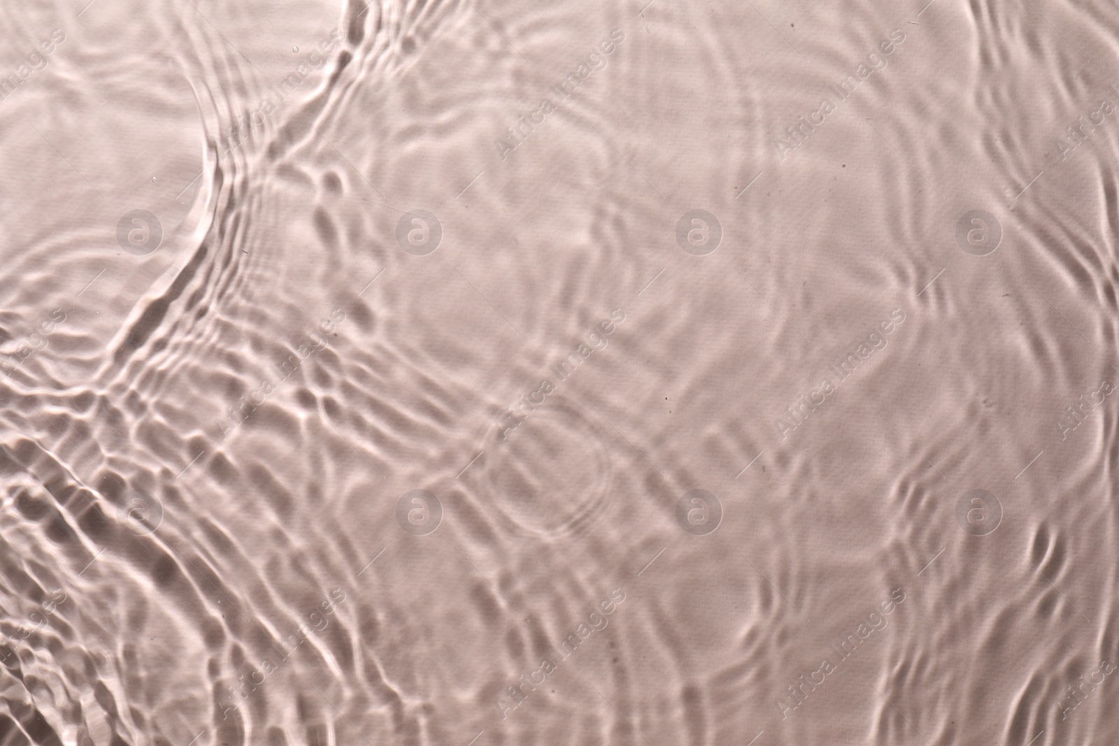 Photo of Rippled surface of clear water on beige background, top view