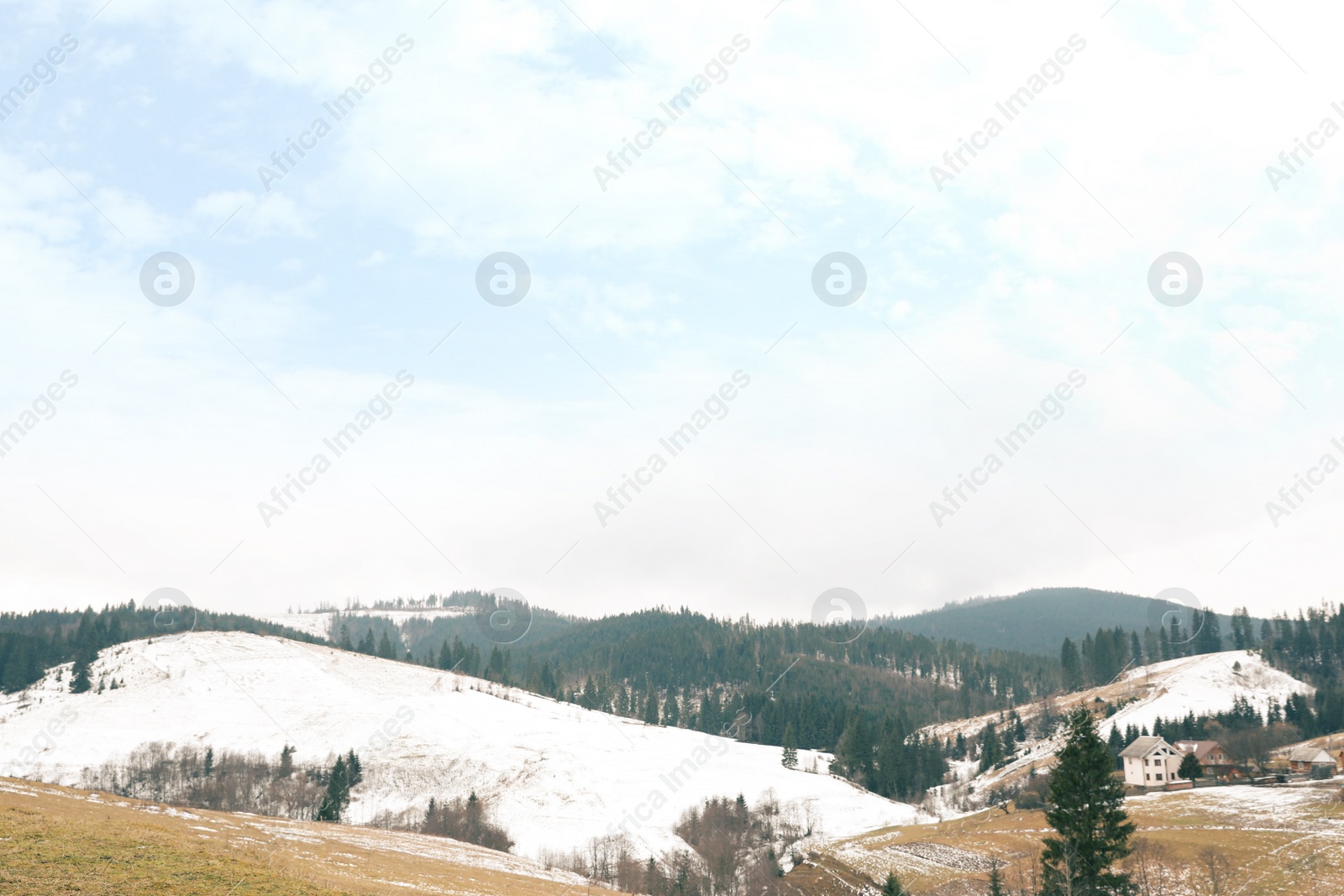 Photo of Beautiful winter landscape with buildings and forest on snowy hills