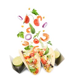 Image of Delicious tacos. Ingredients falling into tortillas on white background