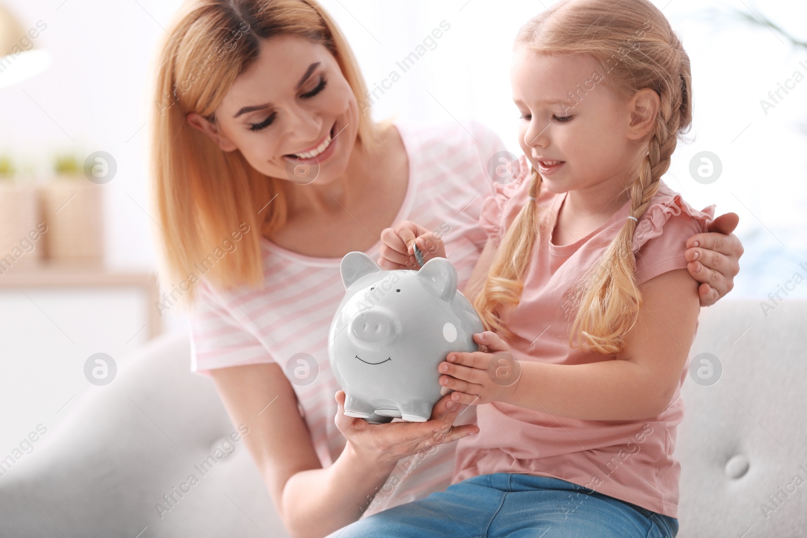 Photo of Family with piggy bank and money at home