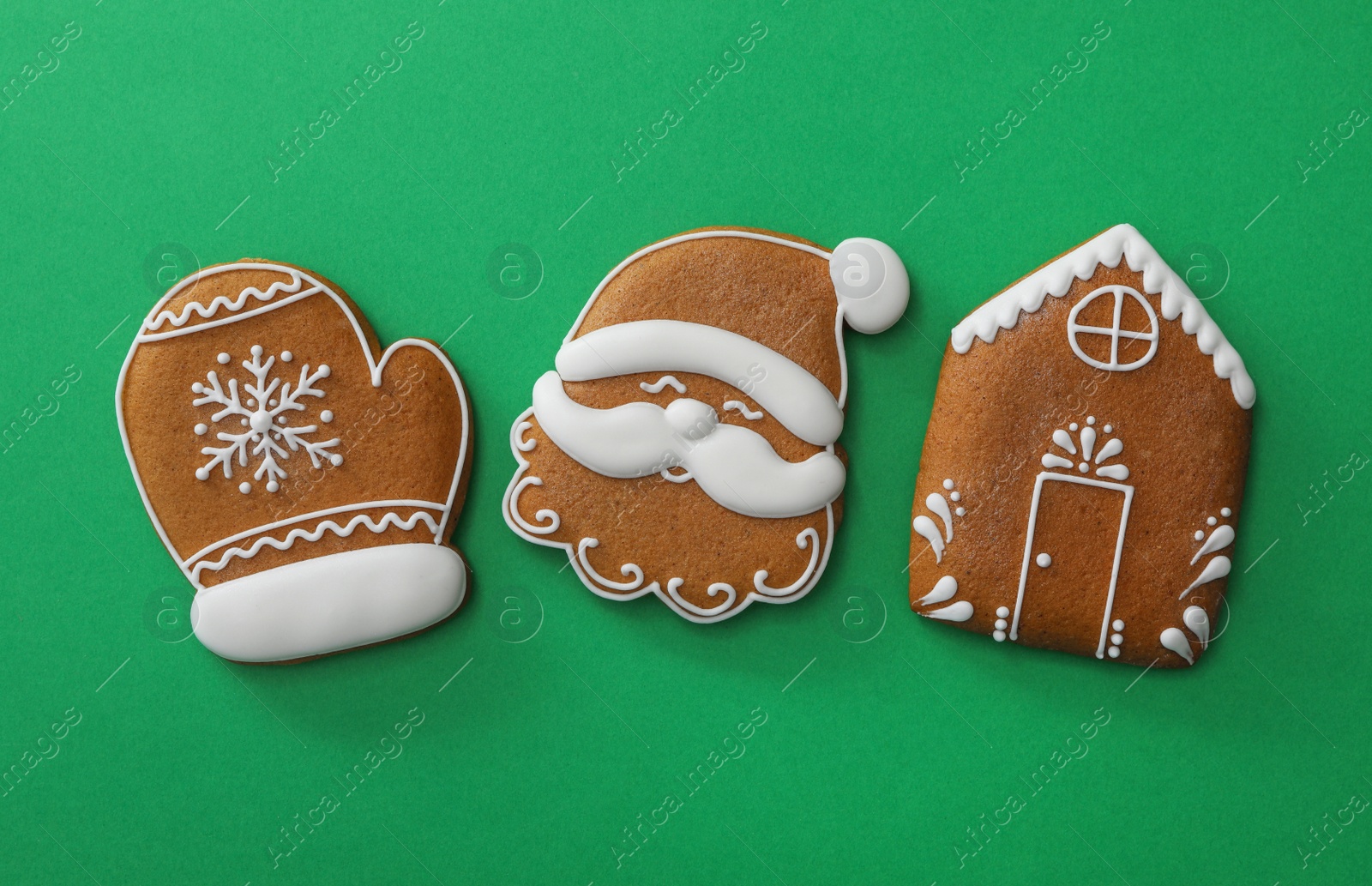 Photo of Different Christmas gingerbread cookies on green background, flat lay