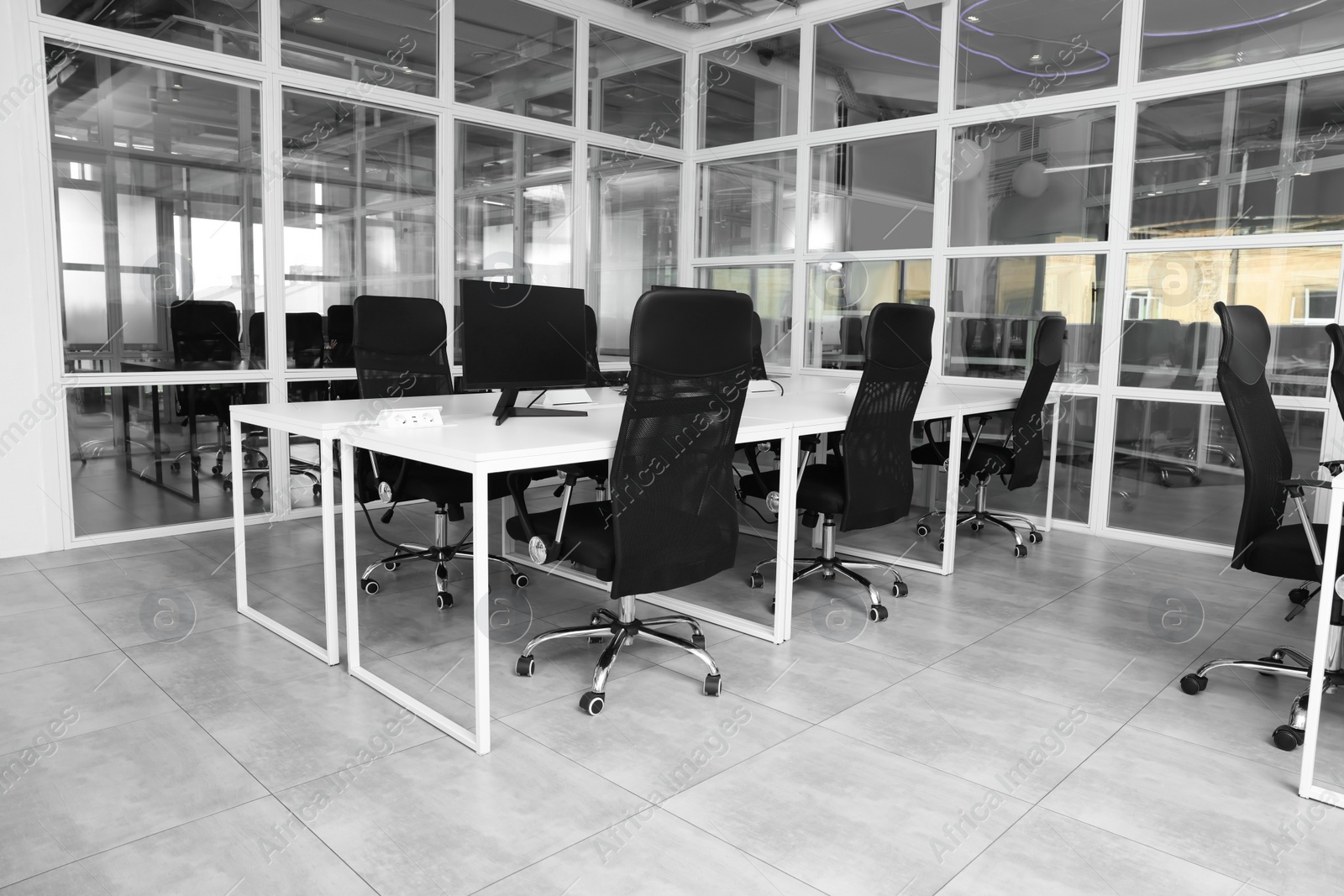 Photo of Stylish interior of open plan office. Workspace with tables and chairs