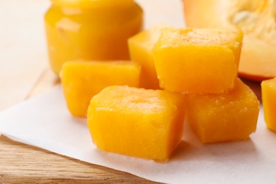 Photo of Frozen pumpkin puree cubes with ingredient on wooden board, closeup