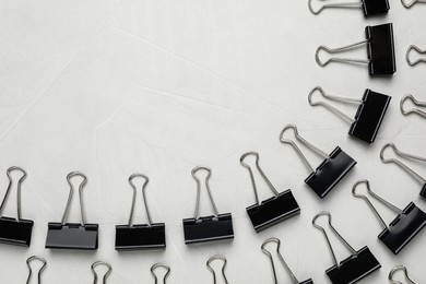 Photo of Binder clips on light background, flat lay. Space for text