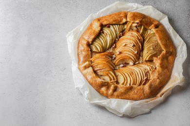 Delicious apple galette with pecans on light gray textured table, top view. Space for text