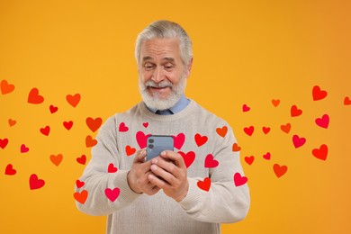 Image of Long distance love. Man chatting with sweetheart via smartphone on golden background. Hearts flying out of device and swirling around him