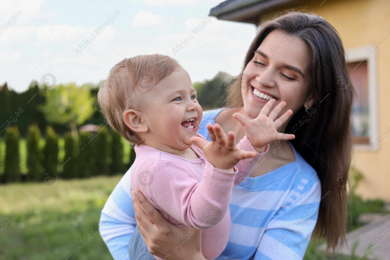 Photo of Happy mother with her cute baby at backyard on sunny day