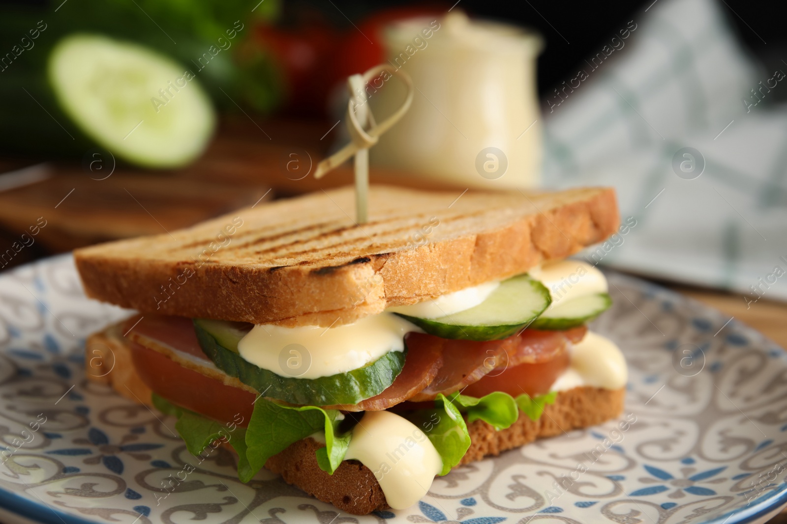 Photo of Delicious sandwich with vegetables, ham and mayonnaise on plate, closeup