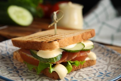 Delicious sandwich with vegetables, ham and mayonnaise on plate, closeup