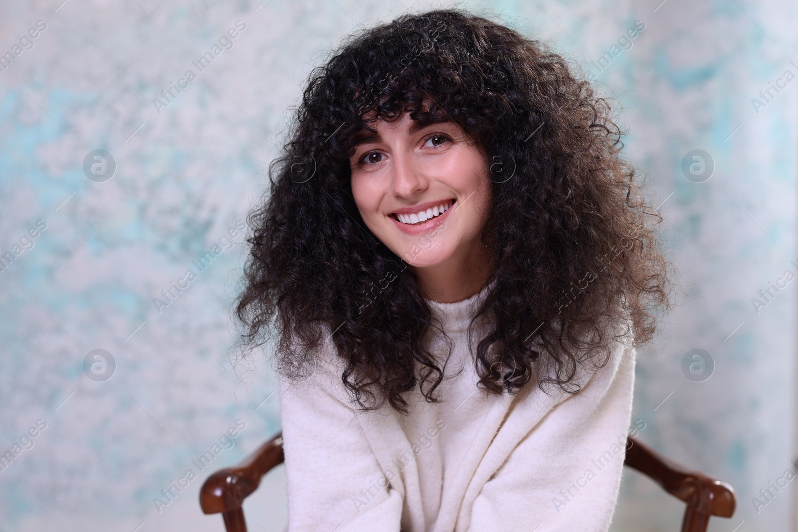 Photo of Happy young woman on chair against color background