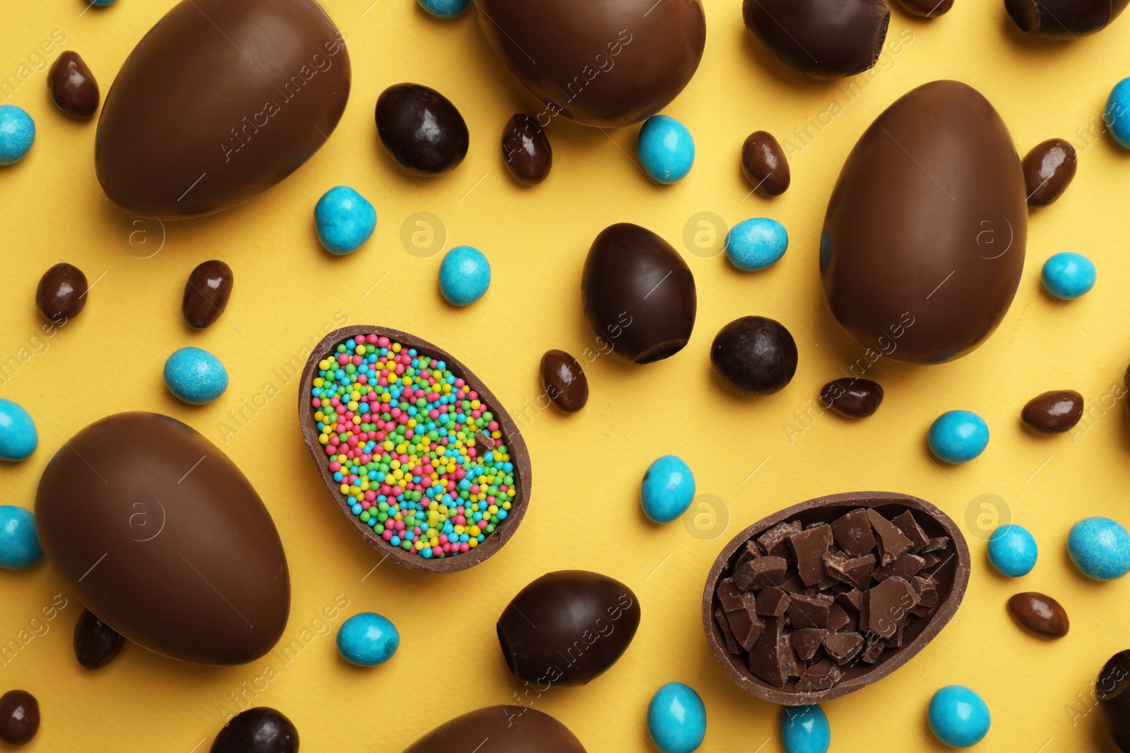 Photo of Flat lay composition with chocolate Easter eggs on color background