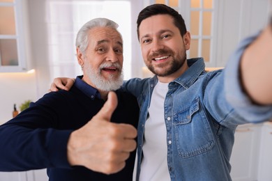 Happy son and his dad taking selfie at home