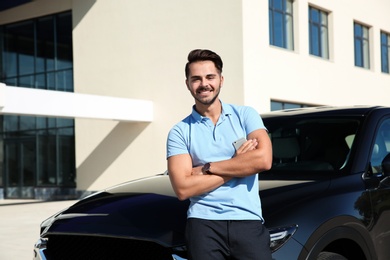 Young man near modern car on sunny day, outdoors