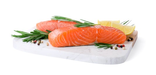 Pieces of fresh raw salmon, spices and lemon slices on white background