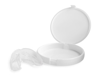 Photo of Transparent dental mouth guard and container on white background. Bite correction