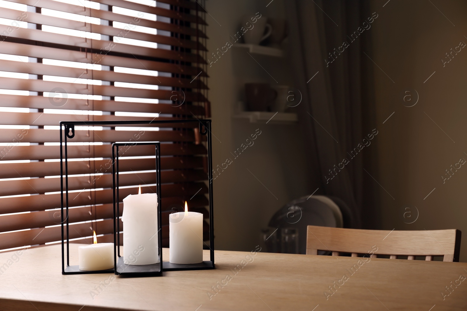 Photo of Wooden dining table with candles in room. Interior design