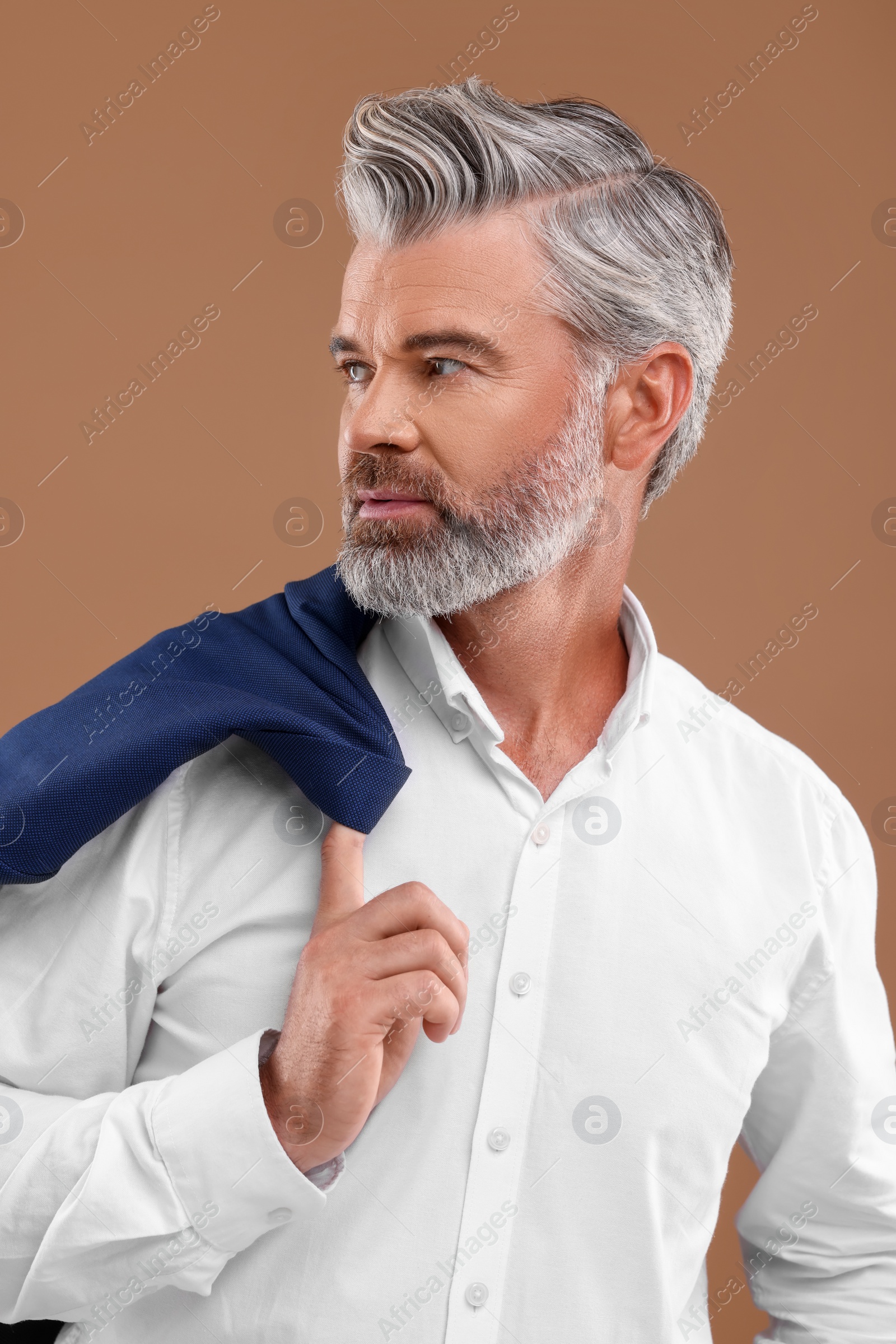 Photo of Portrait of confident man with beautiful hairstyle on light brown background