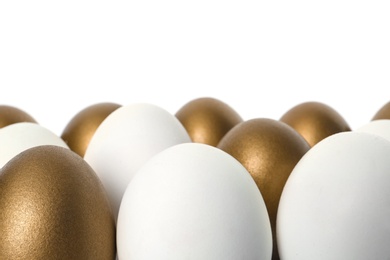 Golden eggs among others on white background