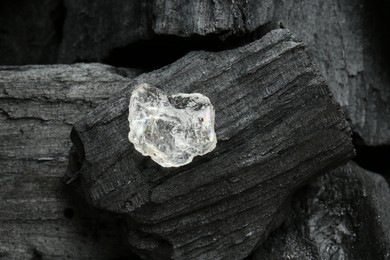 Beautiful shiny diamond on coal, top view