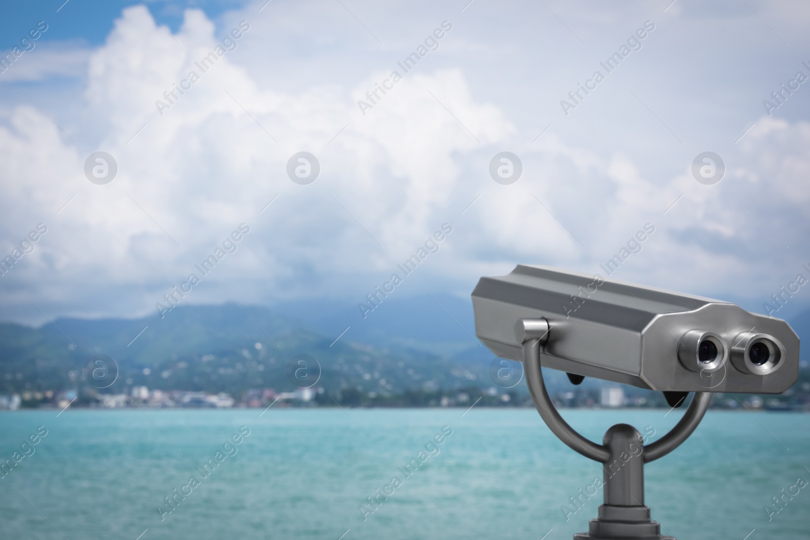 Photo of Metal tower viewer installed near sea, space for text. Mounted binoculars