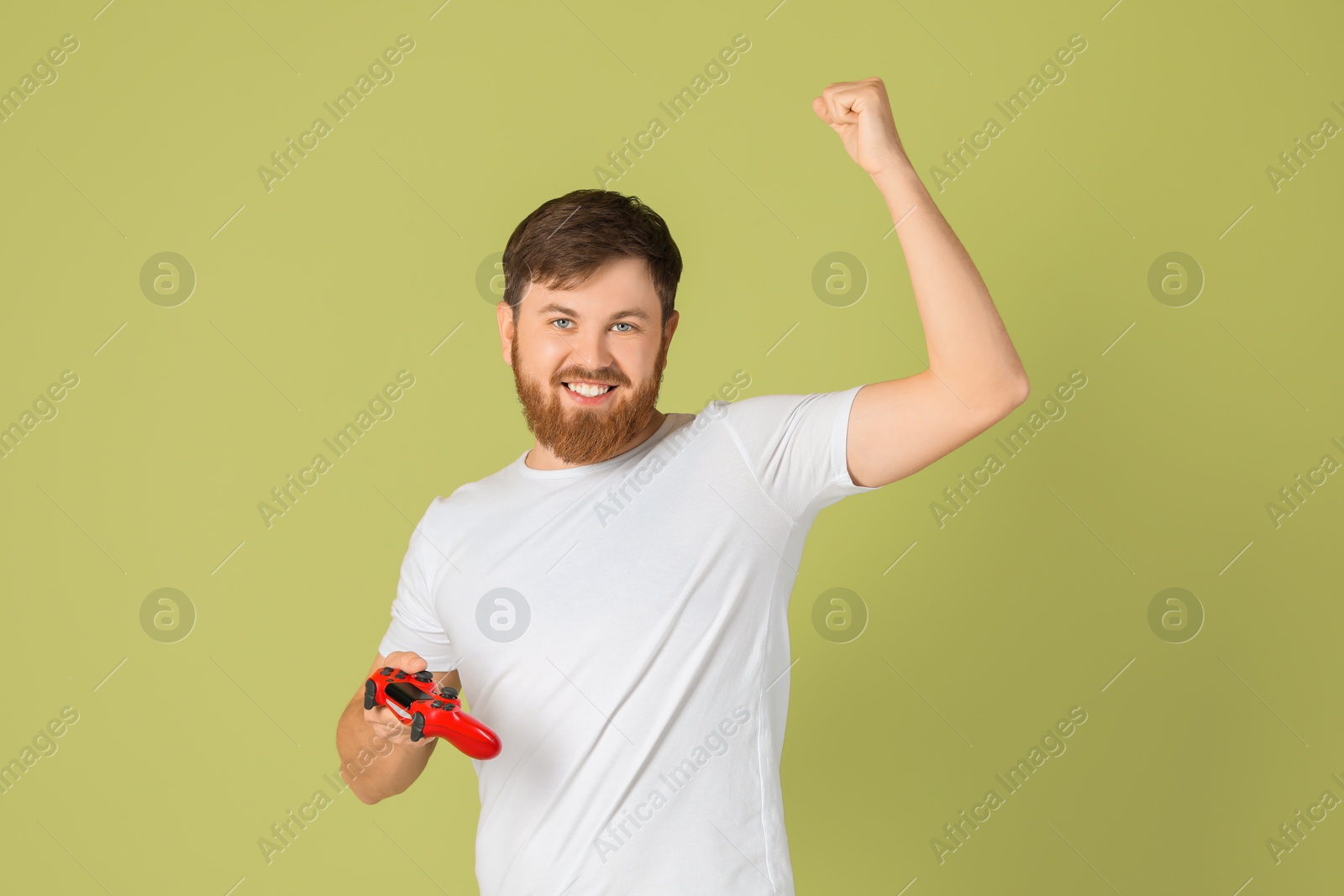 Photo of Happy man with game controller on pale green background