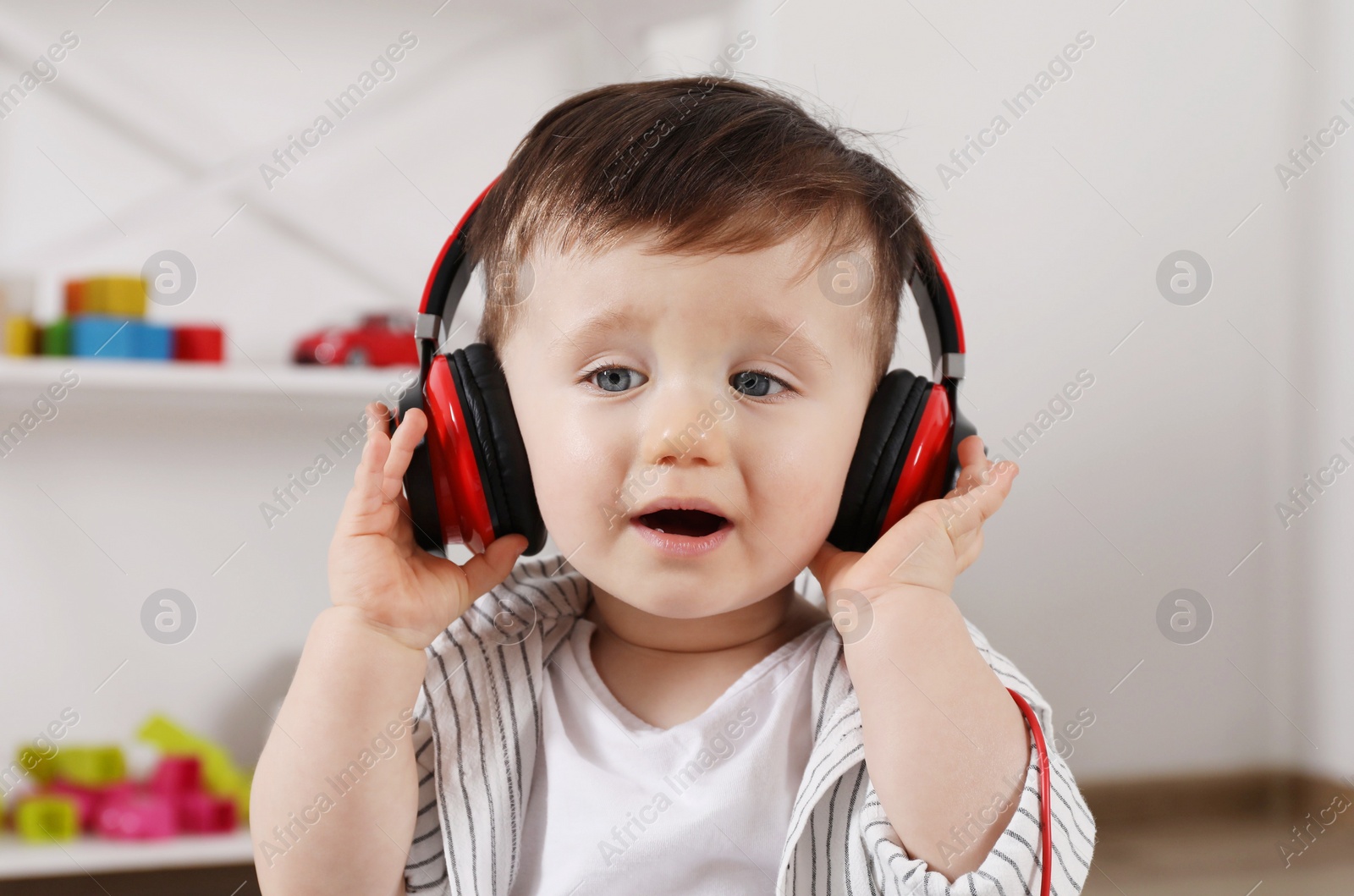 Photo of Cute little boy in headphones listening to music at home