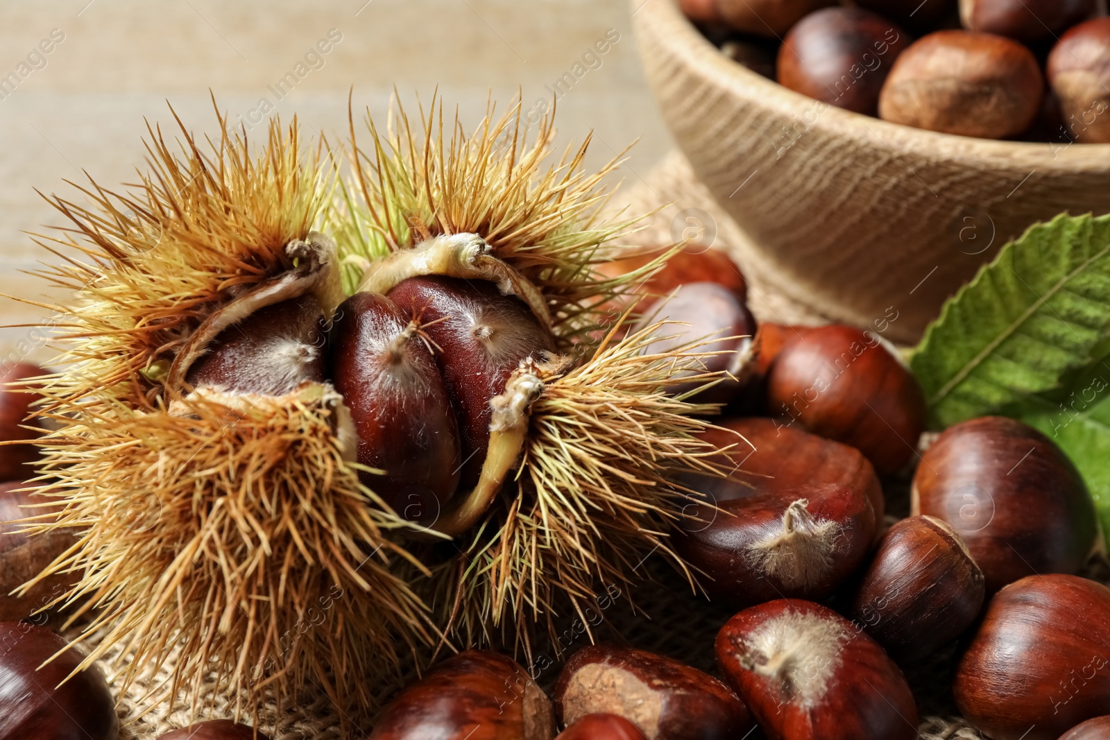 Photo of Fresh sweet edible chestnuts on table, closeup