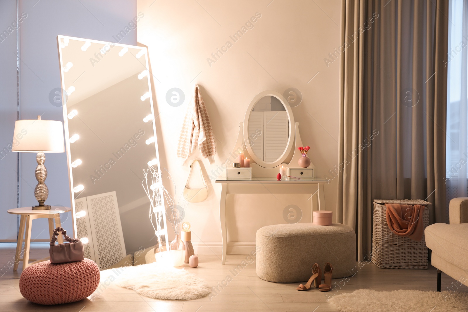 Photo of Large mirror with light bulbs and dressing table in stylish room. Interior design