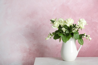 Vase with bouquet of beautiful flowers on table against color background. Space for text