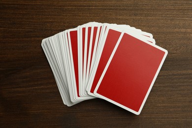 Photo of Deck of playing cards on wooden table, top view. Poker game