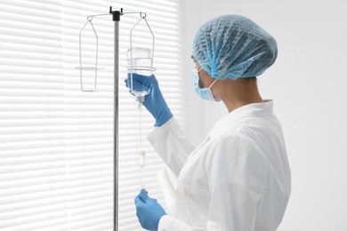 Photo of Nurse setting up IV drip in hospital