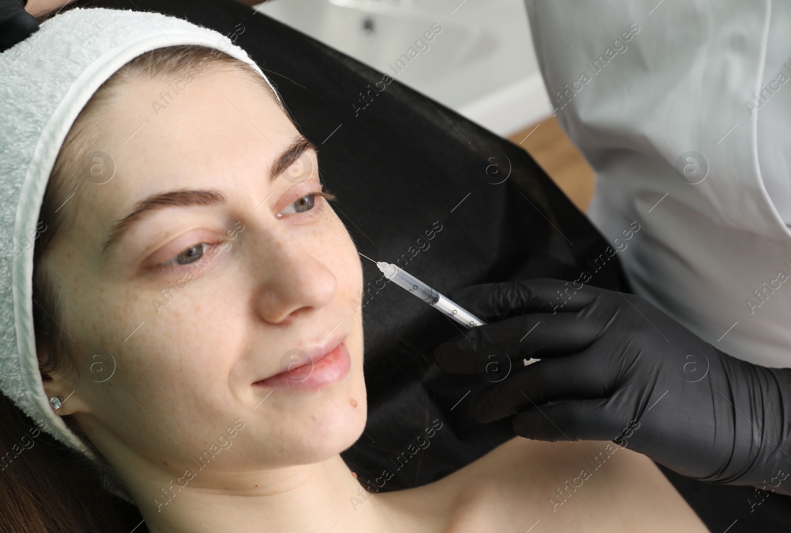 Photo of Cosmetologist giving facial injection to patient, closeup. Cosmetic surgery