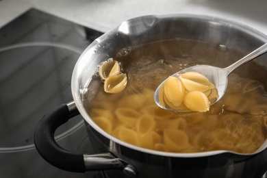 Cooking pasta in pot on electric stove, closeup view