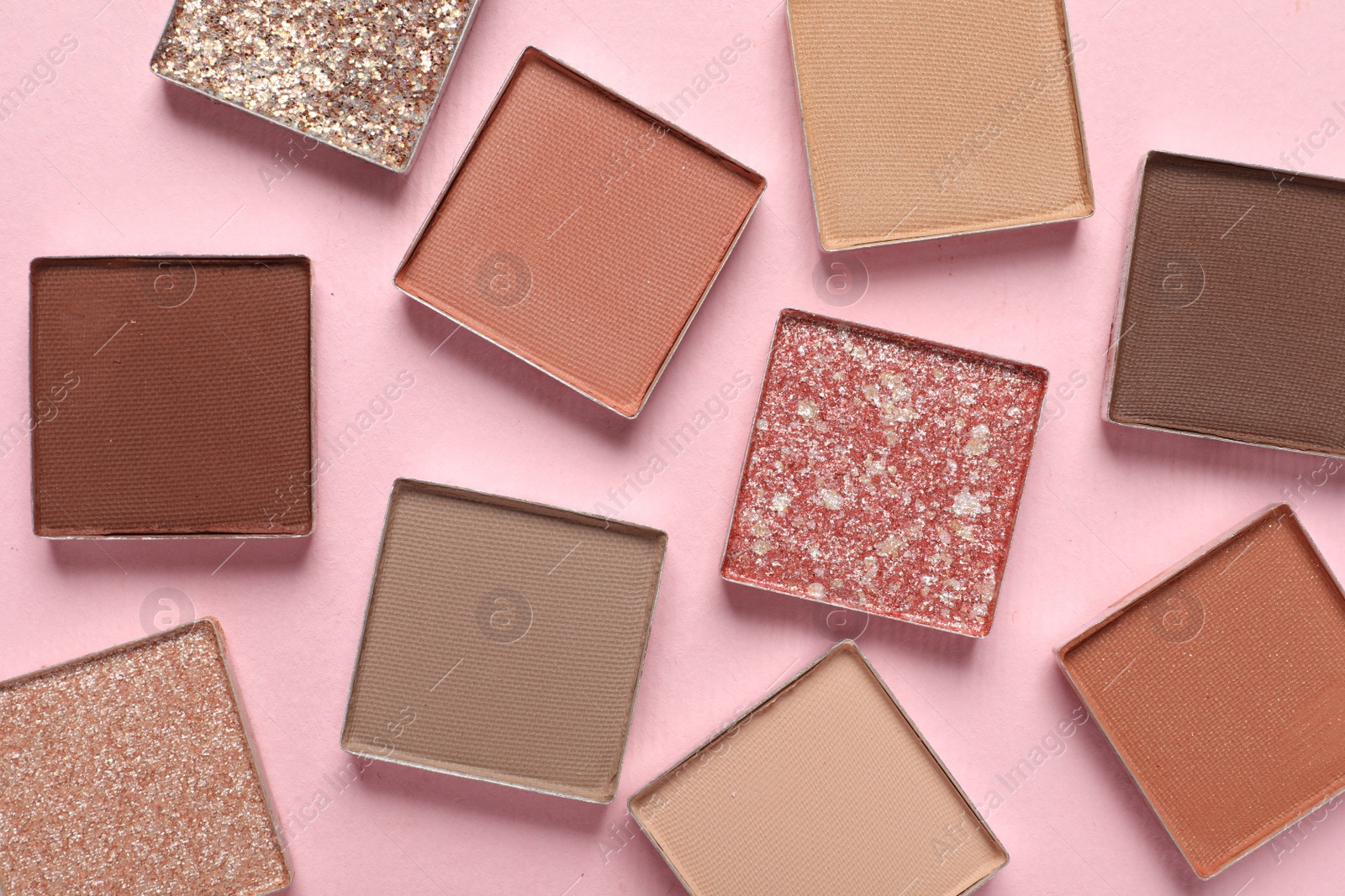 Photo of Different beautiful eye shadows on pink background, flat lay