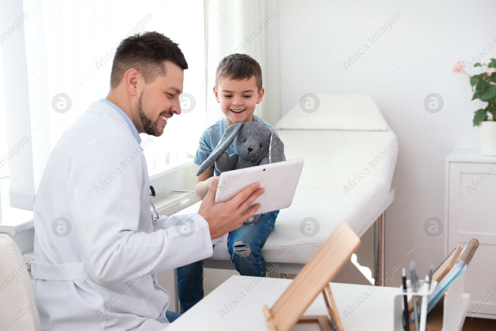 Photo of Children's doctor working with little patient in clinic