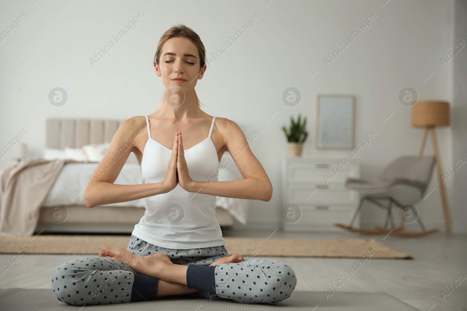 Photo of Young woman meditating on floor at home. Morning fitness