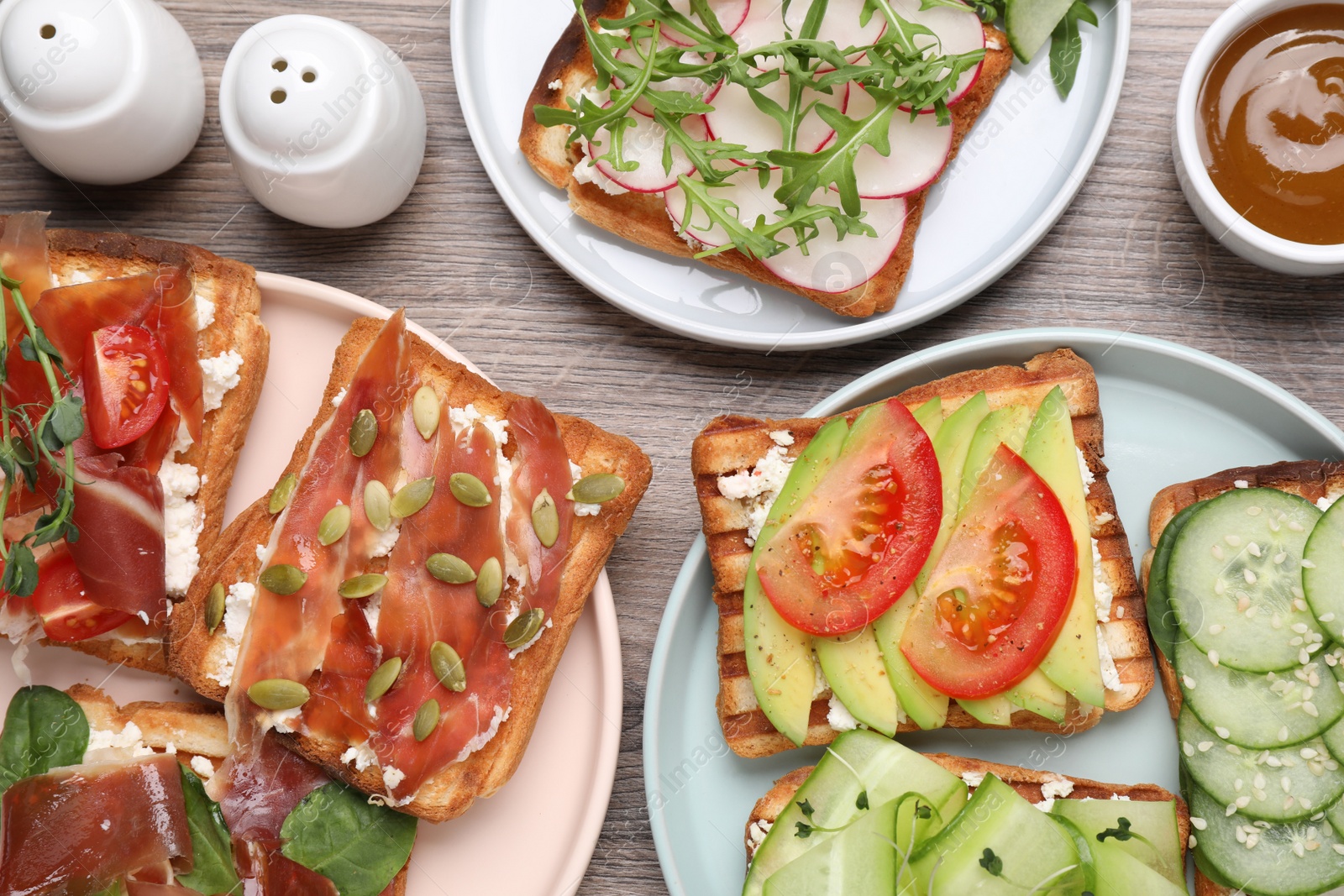 Photo of Different tasty sandwiches served on wooden table, flat lay