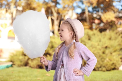 Cute little girl with cotton candy outdoors