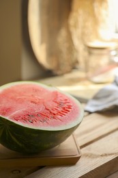 Photo of Half of fresh juicy watermelon on wooden table, closeup. Space for text