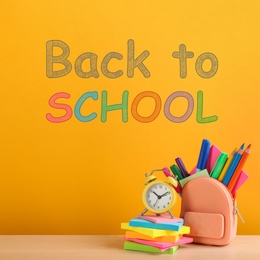 Text Back To School and different stationery on yellow background