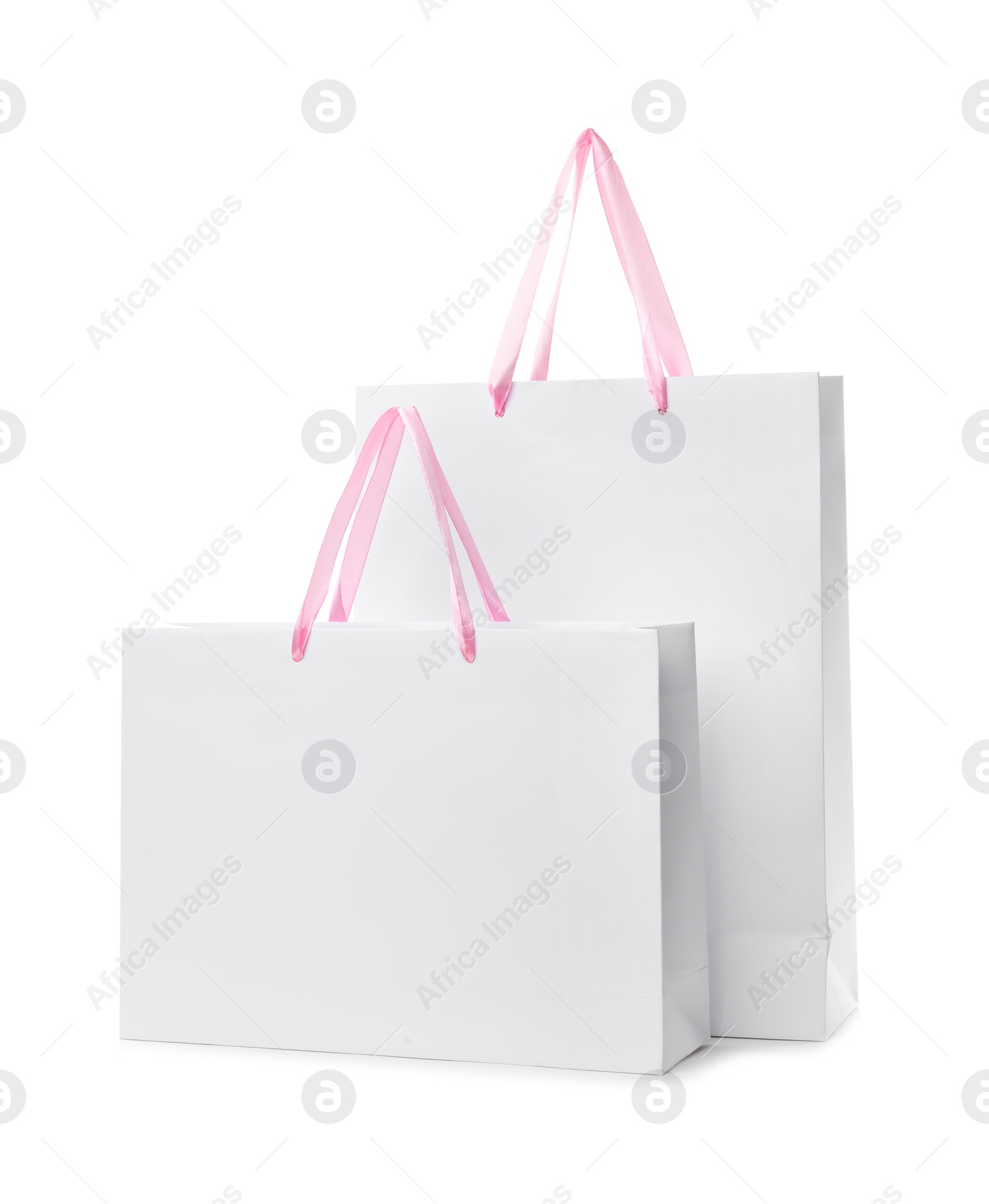 Photo of Paper shopping bags with handles on white background. Mockup for design