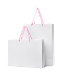 Photo of Paper shopping bags with handles on white background. Mockup for design