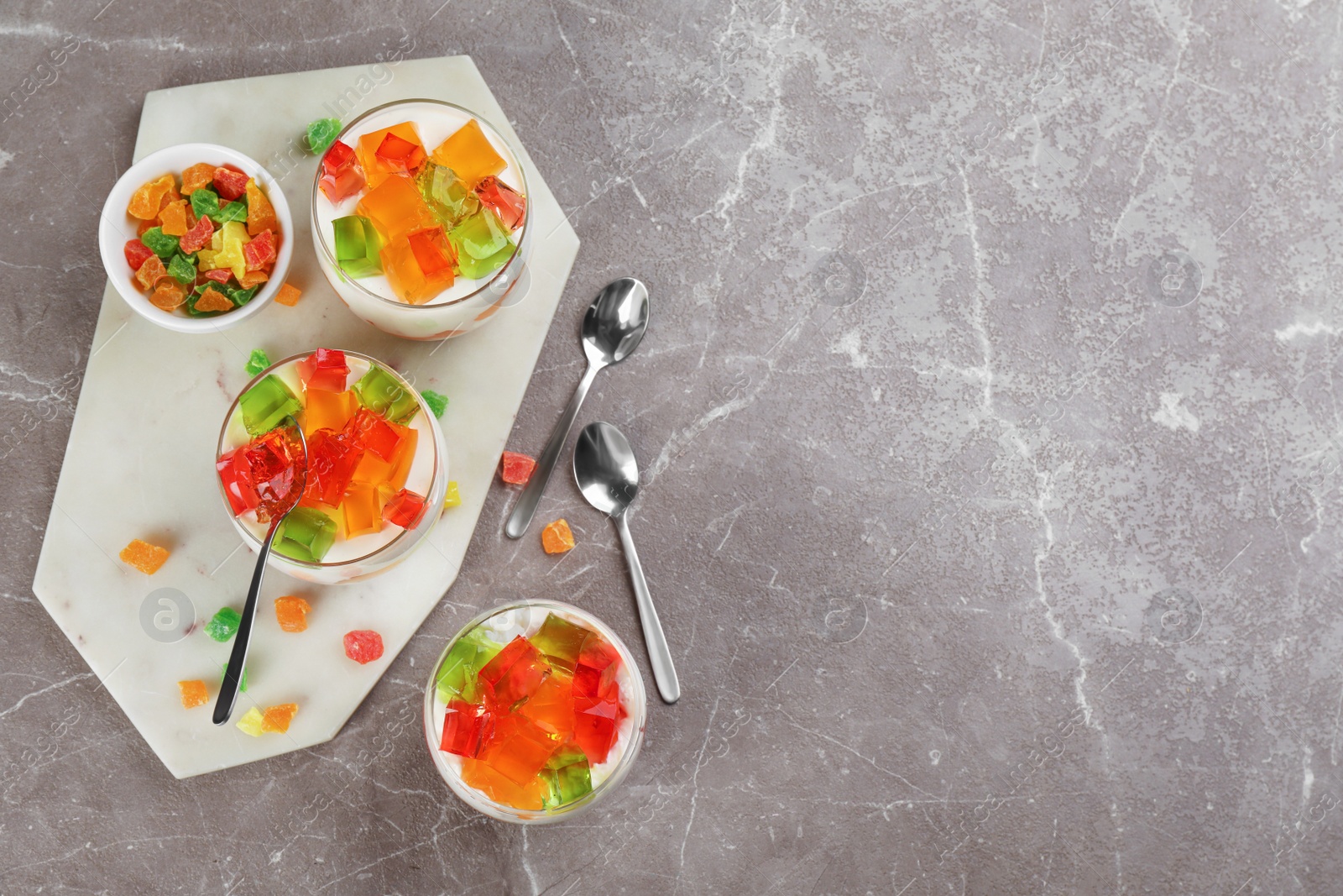 Photo of Delicious broken glass jelly dessert on table, flat lay. Space for text