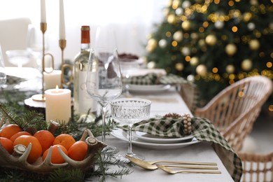 Christmas table setting with festive decor and dishware in room