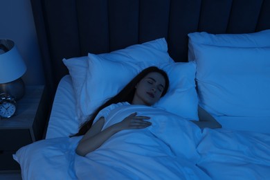 Beautiful young woman sleeping in bed at night