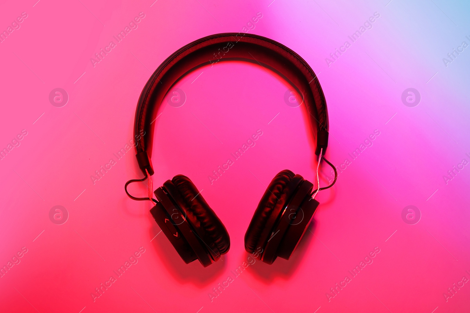 Photo of Stylish headphones on color background, top view